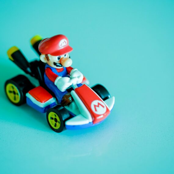 red haired man riding red and blue car plastic toy